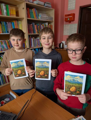 Dzieci w bibliotece wypożyczają książeczkę "Jak to z Grulkiem było"