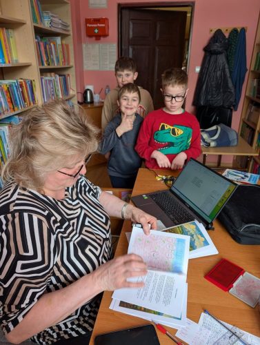 Dzieci w bibliotece wypożyczają książeczkę "Jak to z Grulkiem było"