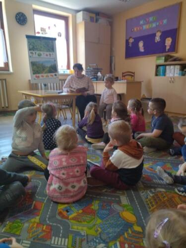 Przedszkolaki słuchają jak zaproszona mama czyta książkę