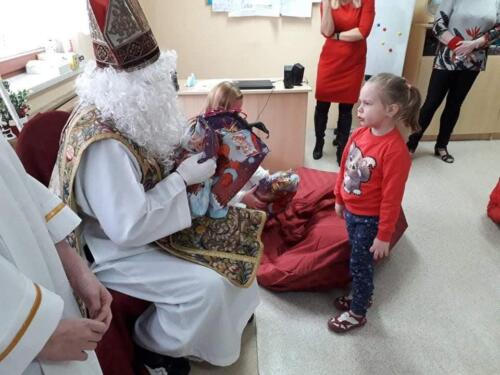 Spotkanie z Mikołajem. Dzieci odbierają prezenty.