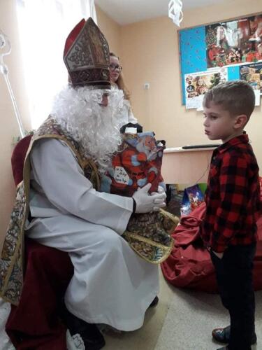 Spotkanie z Mikołajem. Dzieci odbierają prezenty.