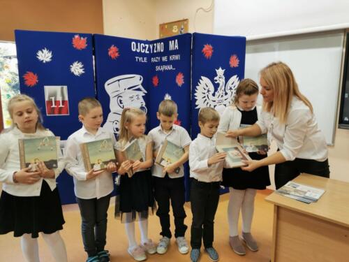 Dzieci otrzymują książeczki "Pierwsze abecadło"