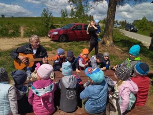 Piknik na szczycie Łapszanki. Dzieci bawią się na łące, pieką kiełbaski i śpiewają piosenki przy akompaniamencie gitary