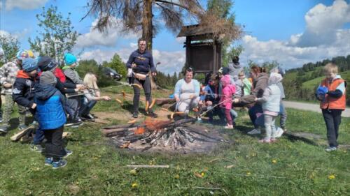 Piknik na szczycie Łapszanki. Dzieci bawią się na łące, pieką kiełbaski i śpiewają piosenki przy akompaniamencie gitary