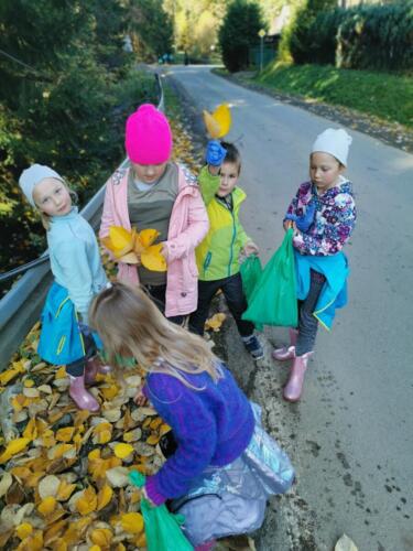 Dzieci w czasie akcji Sprzątanie Świata. Zbierają śmieci i bawią się w jesiennych liściach.