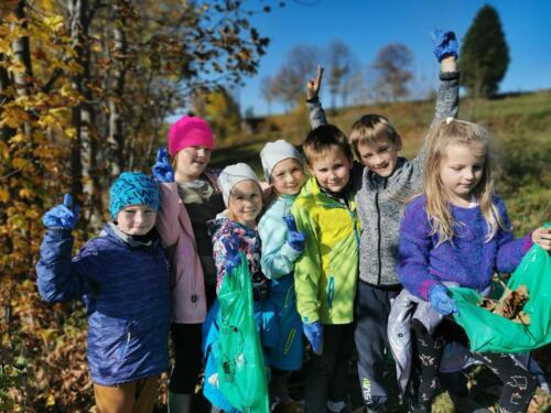 Dzieci w czasie akcji Sprzątanie Świata. Zbierają śmieci i bawią się w jesiennych liściach.