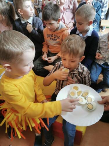 Dzieci podczas spotkania wielkanocnego dzielą się jajkiem