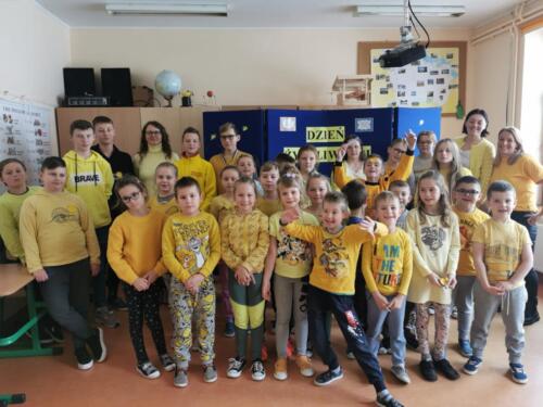 Uczniowie szkoły w czasie dnia życzliwości. Dzieci i nauczyciele ubrani są na żółto.